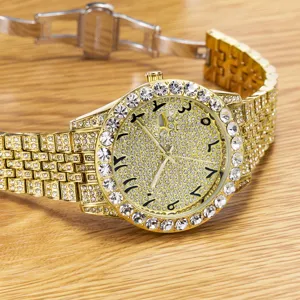 Detailed shot of gold iced out men watch featuring rhinestone dial and metal strap luxury style.