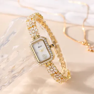 Elegante goldene Damen Armbanduhr mit rechteckigem Zifferblatt und funkelnden Strasssteinen.