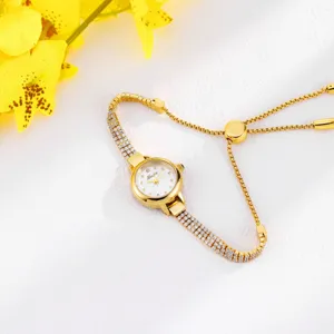 Detail shot of elegant gold women watch with sparkling rhinestones and adjustable slider bracelet.