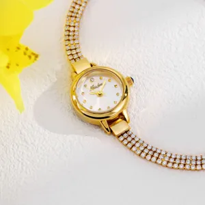 Exquisite gold rhinestone watch dial and crystal encrusted sparkling strap detail view.