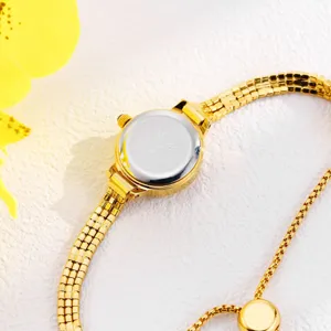 Close-up view of women's gold-tone mini watch featuring a delicate mesh chain strap and pull ball clasp.