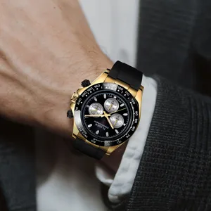 Close-up detail of a gold quartz sport watch with black silicone strap and chronograph dial.