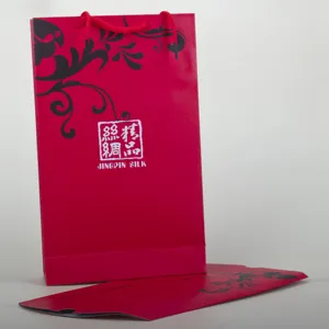Rote Papier-Geschenktüte und Umschlag-Set für Seidenschals mit eleganten Blumenmustern.