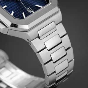 Stainless steel watch detail showing blue dial texture and polished metal bracelet links.