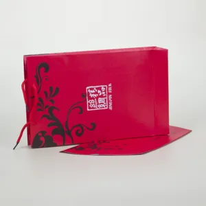Detailaufnahme der roten Papiertasche mit elegantem schwarzen Blumenmuster für Geschenke.