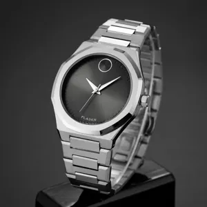 Montre quartz homme avec bracelet en acier inoxydable massif et cadran minimaliste gris foncé.
