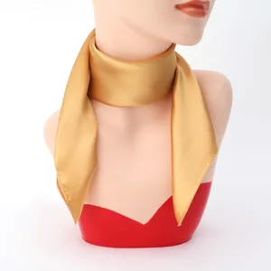 Detail view of a elegant gold silk square scarf, smooth texture for women neckerchief.