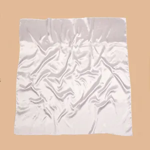 Satin square scarf detail showing smooth texture, elegant drape, and soft fabric material.