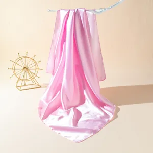 Detailed view of the elegant pink satin square scarf, smooth texture and glossy fabric close-up