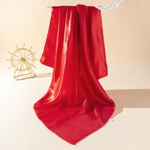 Red satin square scarf detail shot, smooth silk fabric texture, elegant draping display.