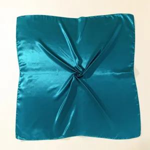 Detailed view of the teal satin square silk scarf showing smooth fabric texture and drape.