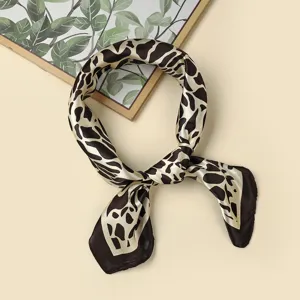 Close-up view of a stylish satin silk scarf featuring a chic abstract animal print design.