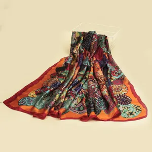 Vue détaillée d'un foulard en soie à motifs colorés drapé élégamment sur un fond neutre.