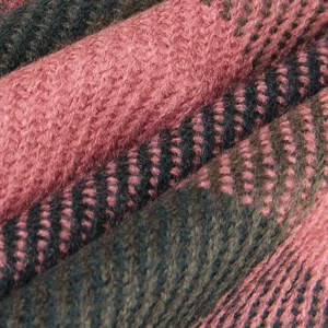 Close-up detail of soft knit scarf texture, cozy winter woolen fabric in pink and dark green.
