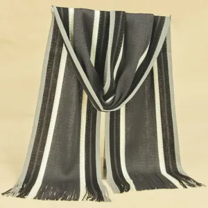 Detail view of stylish men's striped knitted scarf with cozy tassels for winter outdoor warmth.