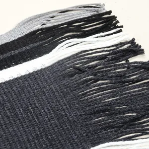 Detailed close-up of men's knitted striped winter scarf focusing on the classic fringe texture.