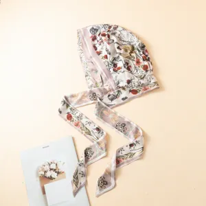 Gorro de seda estampado con lazos largos, detalle de pañuelo vintage elegante.