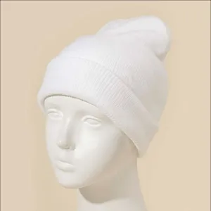 Details en gros plan du bonnet en tricot blanc mettant en valeur la belle texture fine.