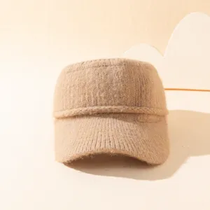 Primer plano de una cómoda gorra de punto beige con textura de lana afelpada para estilo de otoño.