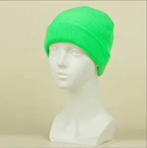 Gros plan sur le bonnet en tricot vert néon montrant la texture côtelée et le design chaud.