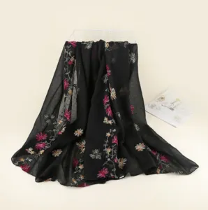 Vue détaillée du châle noir brodé de fleurs colorées montrant des motifs floraux délicats.