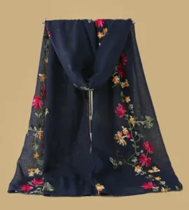 Gros plan détail du foulard bleu foncé brodé de fleurs colorées avec un beau motif de branches.