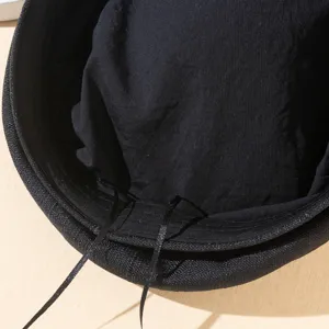 Gros plan de l'intérieur du chapeau noir avec un cordon de serrage réglable pratique.