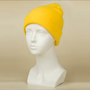 Vue détaillée de bonnet en tricot jaune, texture en tissu acrylique doux, style de chapeau d'hiver.