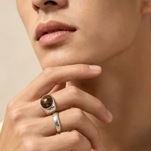 Detail shot of men's vintage tiger eye stone ring and stainless steel polished band.