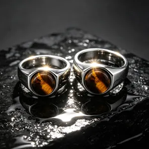 Close-up view of stainless steel men's rings featuring polished bands and natural tiger's eye.