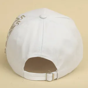 Close-up detail of white baseball cap with gold dragon pattern and adjustable back strap.