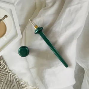 Detail view of the green silicone eyeliner tool with cap, featuring a soft precision silicone tip.