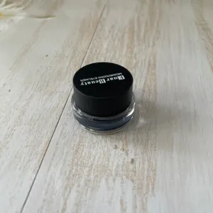 Close-up detail of gel eyeliner pot showing clear container and black cap design.