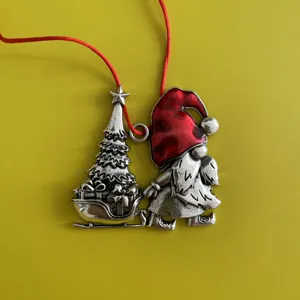 Silver metal Christmas tree and gnome ornament with red hanging cord for holiday decor.