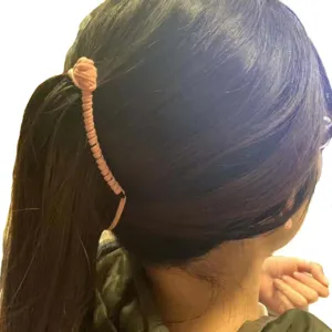 Pink banana hair clip detail showing ponytail styling and fabric wrapped design for use.