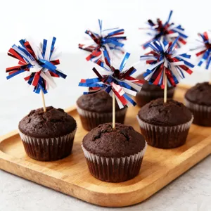 Delicious chocolate cupcakes decorated with red, white and blue tinsel firework picks for parties.