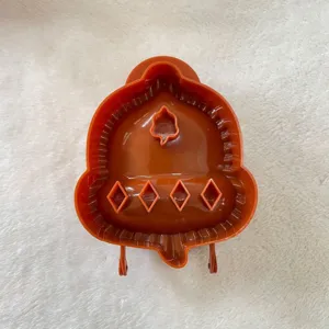 Brown plastic hand pie mold for baking holiday pastries. Durable kitchen tool for pies.