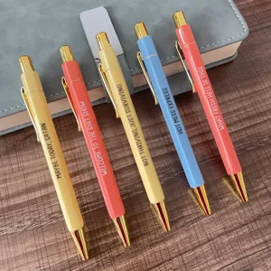 Detailed view of 5 novelty ballpoint pens with funny sarcastic quotes and gold trim finish.