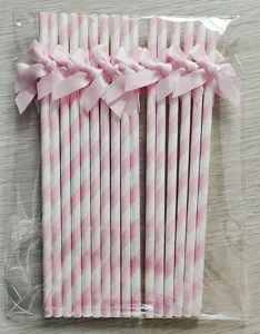 Pailles en papier rayées rose et blanc avec de doux nœuds, parfaites pour la déco de fête.