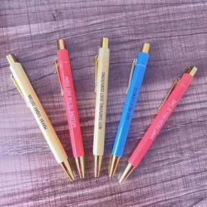 Close-up of colorful novelty ballpoint pens featuring funny quote designs, smooth.