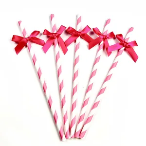 Pink striped paper straws with hot pink bows for party decoration and dessert table setup.