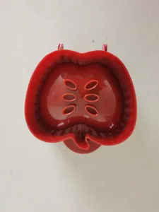 Red apple pie mold detail, plastic baking tool with core cutout for delicious autumn pastries.