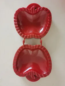 Red plastic apple shaped hand pie mold, open position detail for baking delicious pastries.