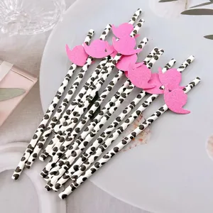 Detailed view of creative cow print paper drinking straws with pink hat decorations for parties.