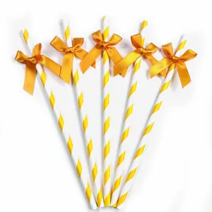 Decorative paper drinking straws with yellow stripes and cute golden bowknots for parties.