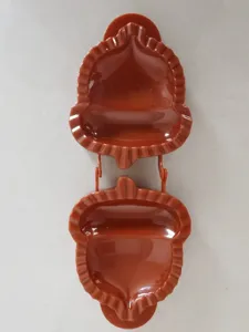Close up view of brown plastic acorn shaped hand pie mold detail with fluted edge.
