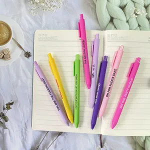 Flachlayout Detailfoto mit bunten Neuheit-Gelstiften und lustigen Zitaten auf Notizbuch.