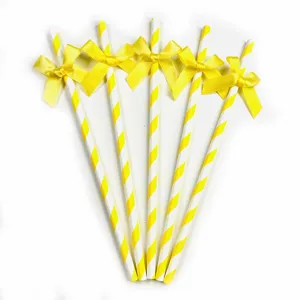 Yellow striped paper straws with satin bows, detail view of party decoration accessories.