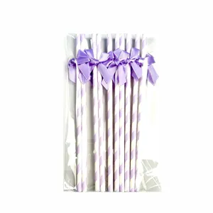 Detail view of purple striped paper straws with elegant satin bows in a clear bag.