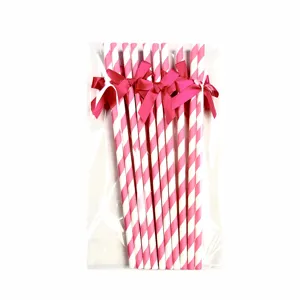 Pink and white striped paper straws with magenta bows, detail view for party and dessert table.